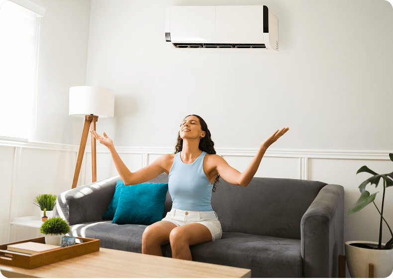 Woman enjoying air conditioning on sofa.